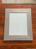Full view of rectangular mirror with textured silver frame