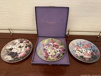 Three floral plates, one displayed in box