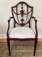 Full front view of mahogany shield-back armchair with ivory seat