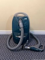Front view of Kenmore canister vacuum with hose and handheld brush