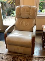 Front view of beige leather La-Z-Boy recliner showing wood arm trim and cushion condition