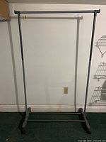 Full frontal view of grey rolling clothing rack