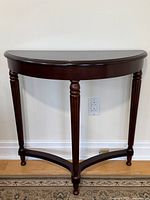 Front view of mahogany demi-lune table showing shape and leg design