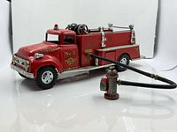 Full view of Tonka fire engine with hose connected to hydrant