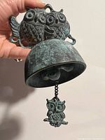 Front view of cast iron door bell showing twin owl backplate, bell cup and owl clapper