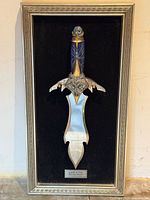 Framed display with knife on black velvet background