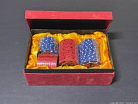 Open red presentation box displaying four wrapped rolls of Bacardi poker chips