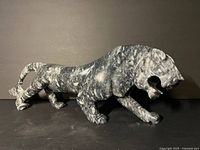 Full side view of grey marble lion sculpture