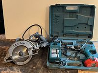 Makita drill set in case alongside Skilsaw saw