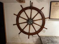 Full view of wooden ship’s wheel mirror mounted on wall