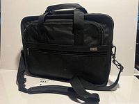 Front view of black Tumi Alpha laptop briefcase with shoulder strap attached