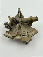 Front view of brass sextant showing scale, index arm, telescope, mirrors