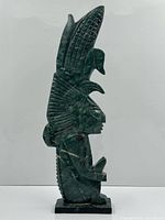 Left side view showing full carved figure and base