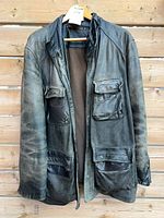 Front view of black leather jacket showing four pockets, zipper and snap placket