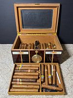 Humidor open showing interior tray, cigars for scale
