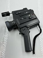 Left side view showing full camera, lens, microphone, grip and strap