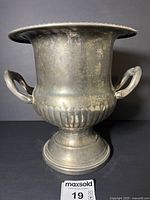 Full view of silver-plated champagne bucket on pedestal base with handles