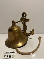Full view of brass ship bell with anchor bracket and rope pull