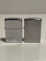 Front view of two chrome Zippo lighters closed