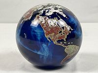 North and South America view of glass globe paperweight