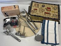 Group shot of utensils, pizza stone, placemats, towel, sharpener, thermometers