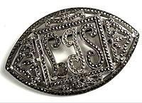 Full view of sterling silver navette brooch with marcasite stones and scroll initials
