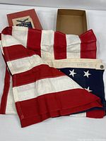 Flag partially unfolded with box and lid visible