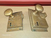 Front view of both brass locksets showing knobs and keyholes