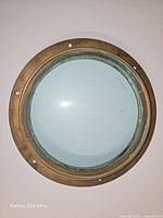 Front view of brass porthole with glass