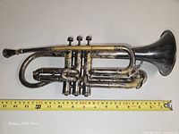 Right-side view of entire trumpet with measuring tape showing length