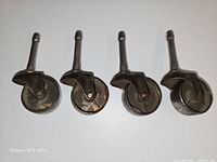 Four steel casters upright showing wheels and stems