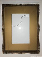 Front view of gold-tone ornate wood frame showing cracked glass