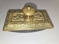 Top angled view showing brass relief panel and knob, wood rocker underside visible