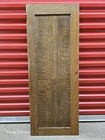 Front view of tiger oak cabinet door against red background