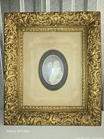 Front view of ornate gold gilt frame with oval photo