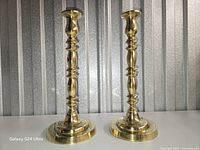 Front view of both polished brass candlesticks