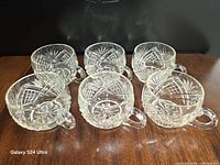 Top view of six cut glass punch cups showing pattern and handles