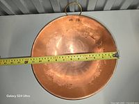 Interior view of brass mixing bowl with measuring tape showing diameter and brass hanging ring