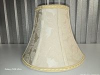Oblique view showing damask pattern, bell shape and trim