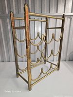 Three-quarter view of brass wine rack showing four tiers and structure
