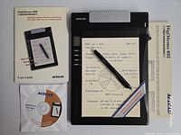 Top-down view of DigiMemo DM-692 tablet, pen, software CD, user guide and reference card