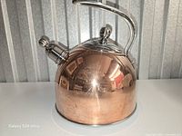 Front view of copper and stainless steel whistling kettle
