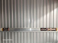 Full view of the 98-inch aluminum cutting guide against corrugated backdrop