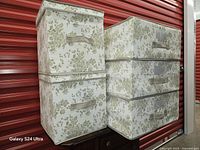 Front view of five matching floral foldable boxes stacked