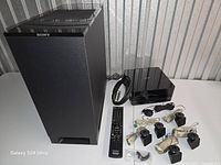 All components laid out: subwoofer, DVD receiver, remote, speakers, wires, sensor