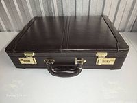 Angled top view of closed briefcase showing leather surface and stitching