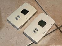 Front view of both Honeywell digital thermostats on tile floor