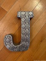 Front view showing ornate filigree design on letter J