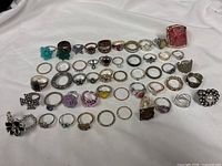 overview of all 50 rings laid out on white fabric