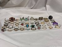 Full group of 50 assorted rings displayed on white fabric